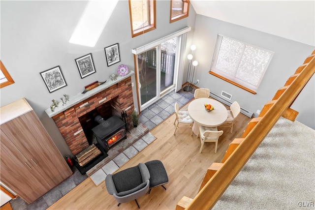 living room featuring a fireplace, wood-type flooring, and a towering ceiling