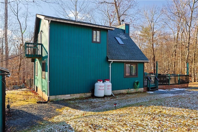 view of property exterior with a balcony and a deck