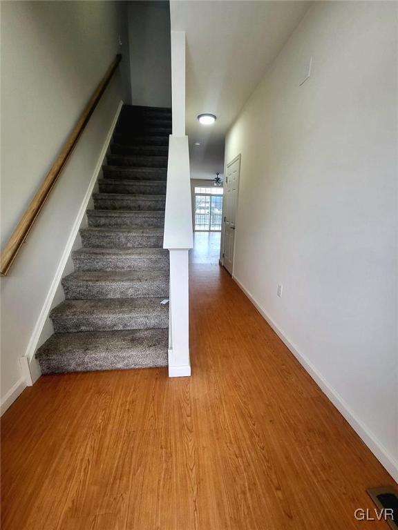 staircase with hardwood / wood-style floors