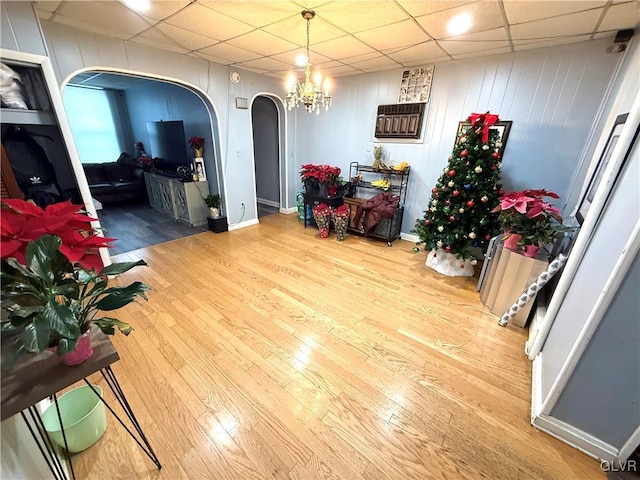 interior space featuring hardwood / wood-style flooring, a paneled ceiling, and an inviting chandelier