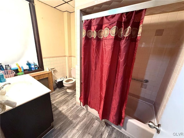 full bathroom featuring vanity, toilet, tile walls, wood-type flooring, and shower / tub combo