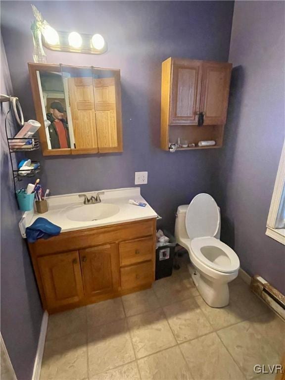 bathroom with tile patterned floors, vanity, toilet, and baseboard heating