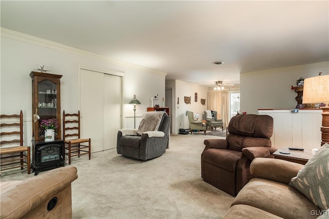 carpeted living room featuring a wood stove, ceiling fan, and crown molding