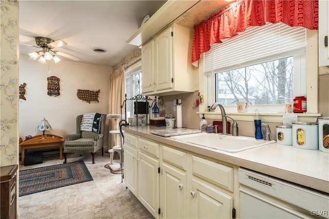 kitchen featuring ceiling fan, dishwasher, cream cabinetry, and sink