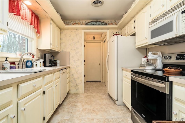 kitchen featuring white appliances, sink, and light tile patterned floors