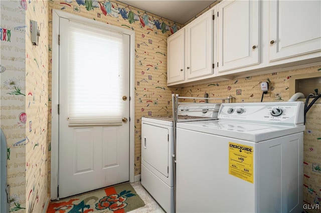 laundry area with washing machine and clothes dryer and cabinets