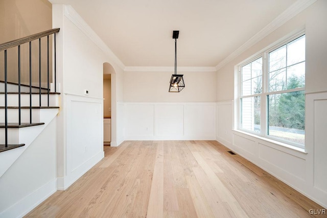 unfurnished dining area with light hardwood / wood-style floors and crown molding