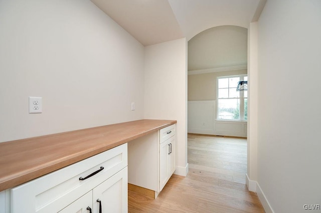 interior space with built in desk, white cabinetry, and light wood-type flooring