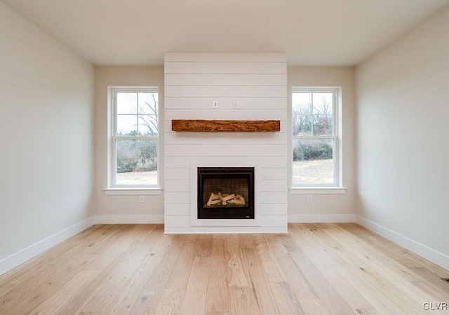 unfurnished living room with light hardwood / wood-style floors and a large fireplace