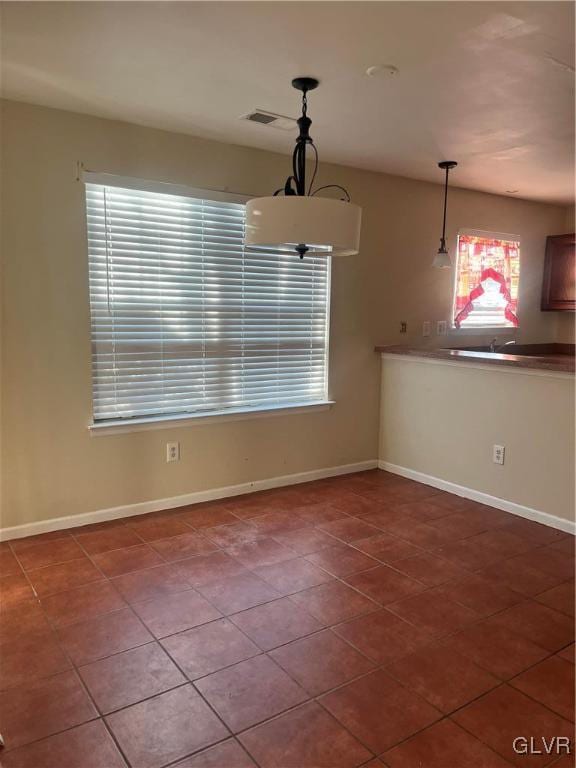 unfurnished dining area featuring tile patterned floors