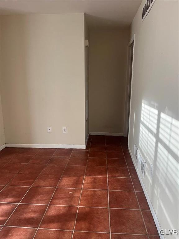 hall featuring dark tile patterned flooring