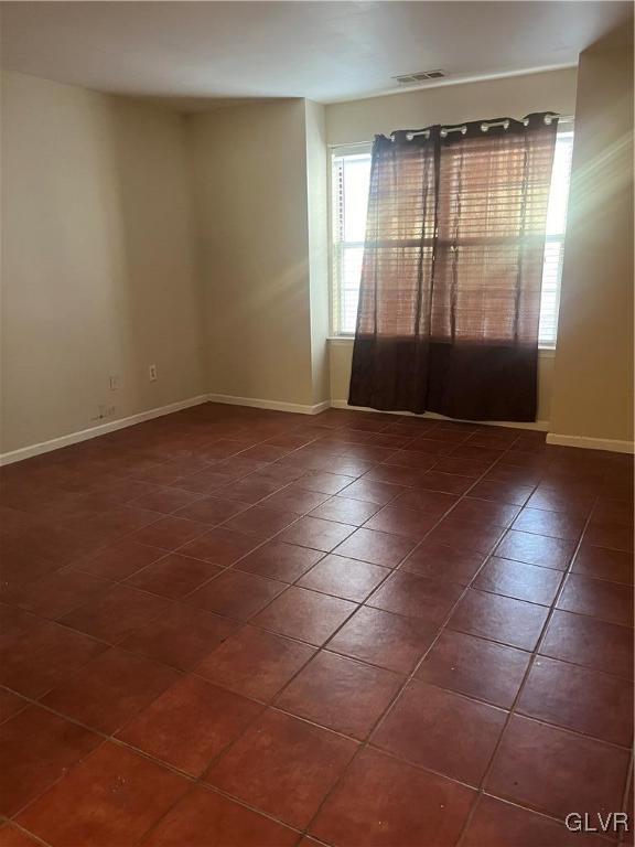 spare room with dark tile patterned floors