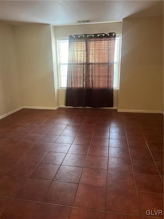 spare room with dark tile patterned floors