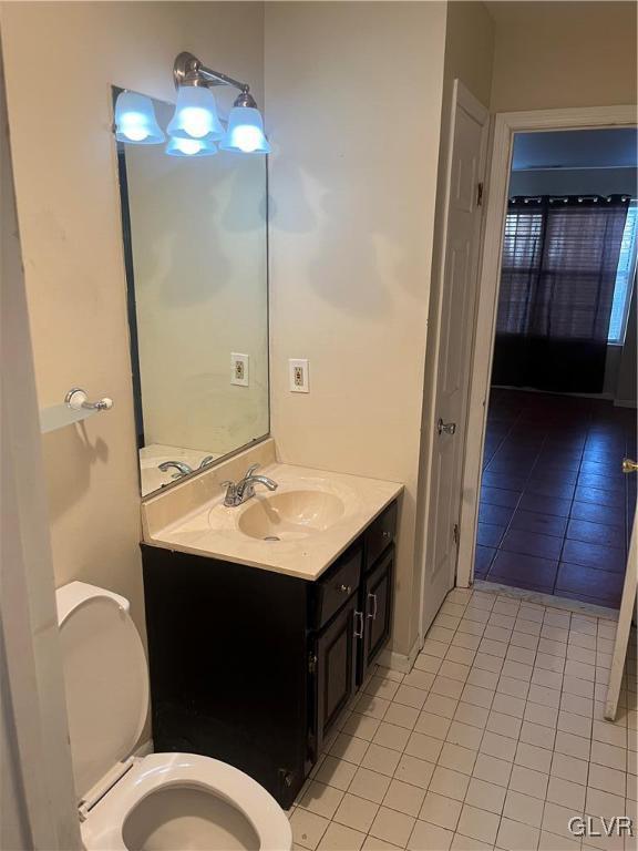 bathroom with tile patterned flooring, vanity, and toilet