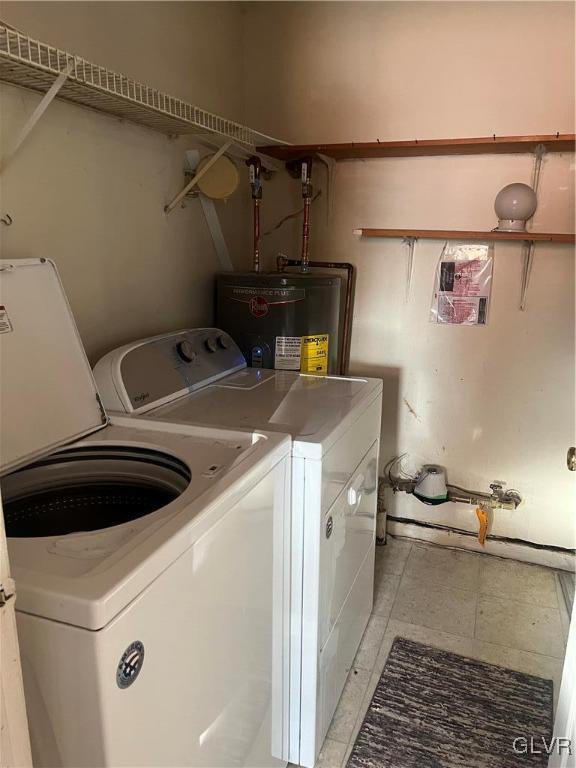 clothes washing area featuring washing machine and dryer and gas water heater