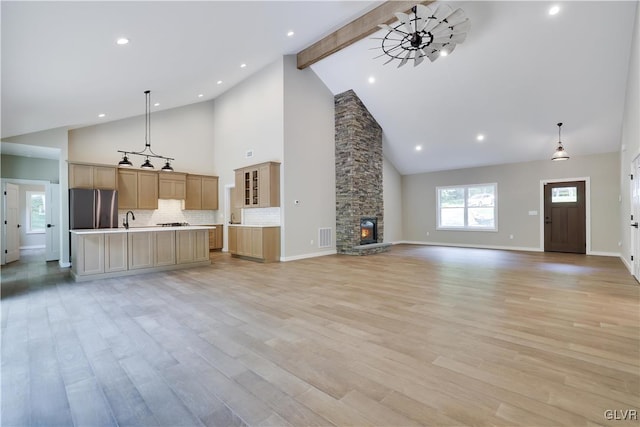 unfurnished living room with beamed ceiling, high vaulted ceiling, light hardwood / wood-style flooring, and sink