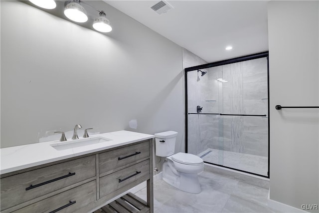 bathroom with a shower with door, vanity, and toilet