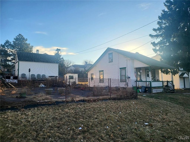 view of home's exterior with a lawn and covered porch