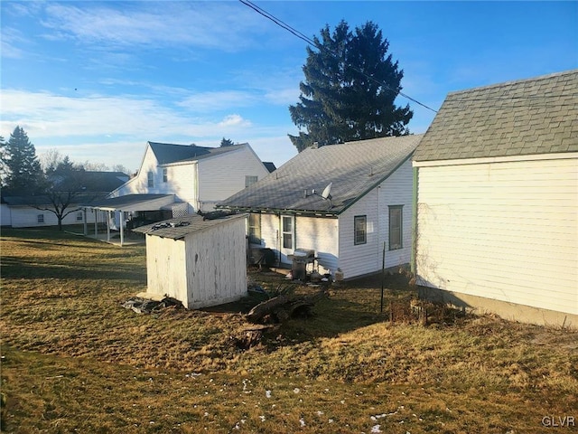 view of side of home with a storage shed and a lawn