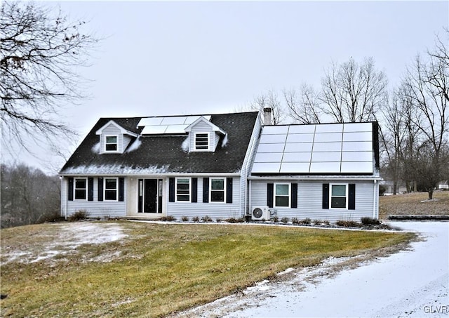 cape cod home with a yard and solar panels