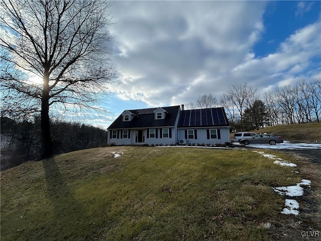 new england style home with a front lawn and solar panels