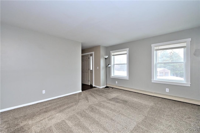 empty room with baseboard heating and carpet