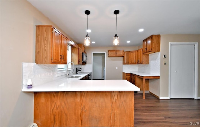 kitchen featuring decorative light fixtures, dark hardwood / wood-style floors, kitchen peninsula, and tasteful backsplash