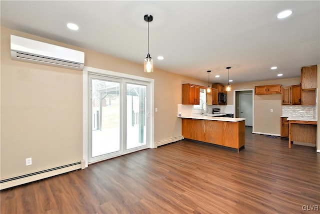 kitchen with a wall mounted AC, kitchen peninsula, dark wood-type flooring, hanging light fixtures, and sink