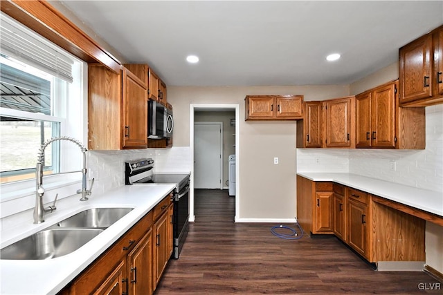 kitchen with dark hardwood / wood-style floors, washer / dryer, decorative backsplash, sink, and stainless steel range with electric cooktop