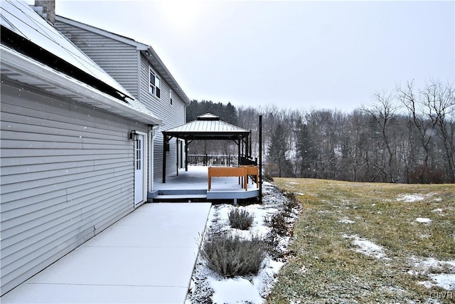 yard covered in snow featuring a wooden deck and a gazebo