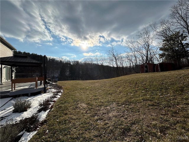 view of yard featuring a wooden deck, a gazebo, and a storage unit