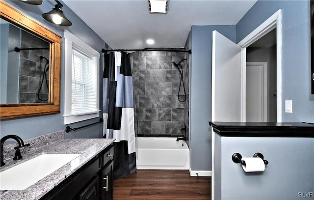 bathroom featuring hardwood / wood-style flooring, vanity, and shower / bath combo