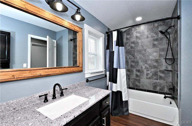 bathroom featuring shower / bathtub combination with curtain, hardwood / wood-style flooring, and vanity