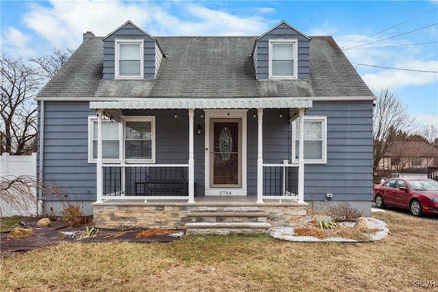 cape cod home featuring a front yard and a porch