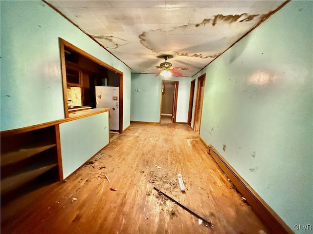 empty room with ceiling fan, light hardwood / wood-style floors, and a baseboard radiator