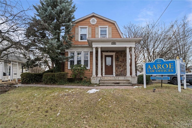 neoclassical home featuring a front lawn