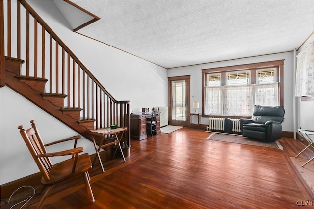 interior space with radiator heating unit, a textured ceiling, and wood-type flooring