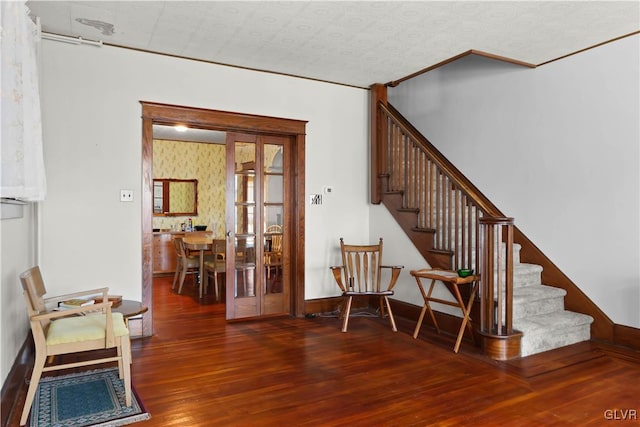 stairway with french doors and hardwood / wood-style floors