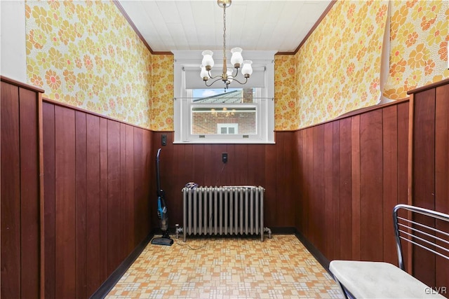 interior space featuring radiator, crown molding, and a notable chandelier