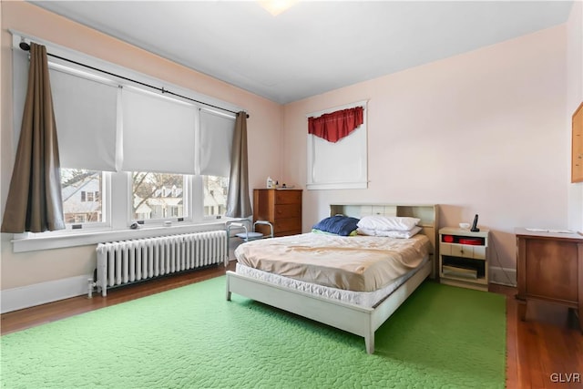 bedroom featuring hardwood / wood-style flooring and radiator