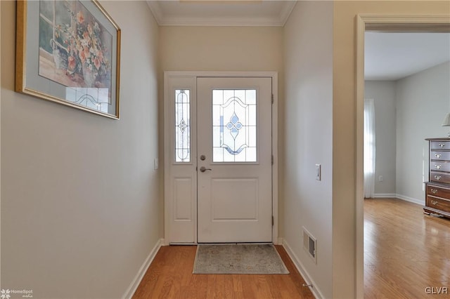 doorway to outside with ornamental molding and light hardwood / wood-style flooring