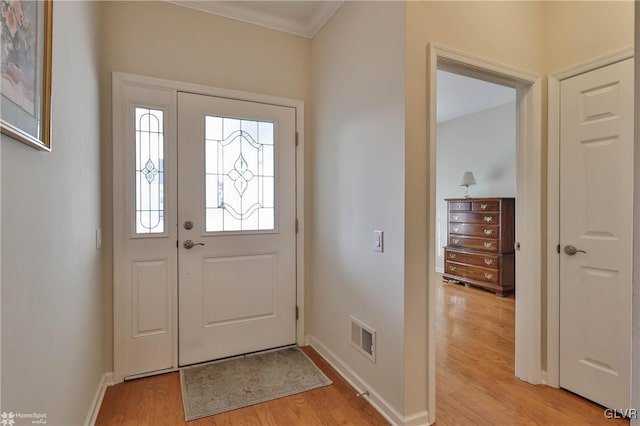 entryway with light hardwood / wood-style floors and crown molding