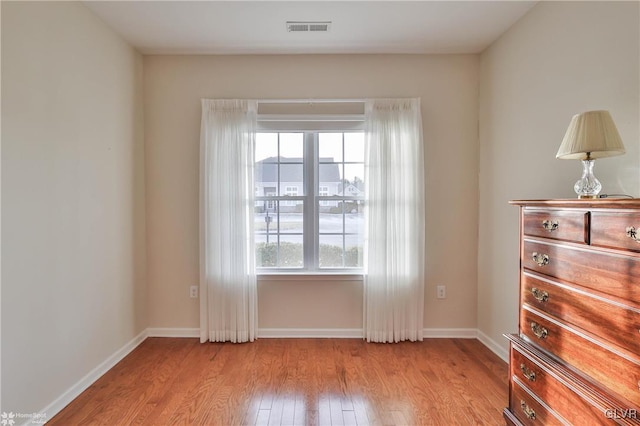 unfurnished room featuring light wood-type flooring and plenty of natural light