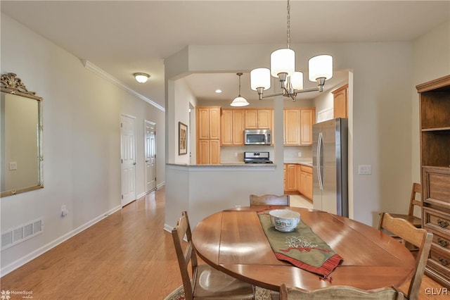 dining space featuring a chandelier, light hardwood / wood-style floors, and ornamental molding