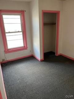 unfurnished bedroom with a closet and carpet flooring