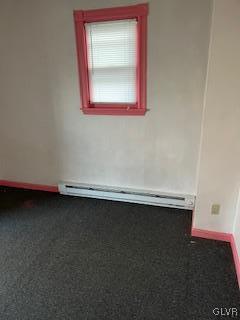 unfurnished room featuring baseboard heating