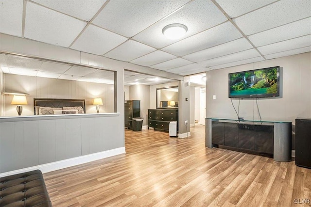 interior space with a paneled ceiling and hardwood / wood-style flooring