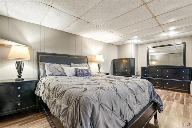 bedroom with a drop ceiling and light hardwood / wood-style floors