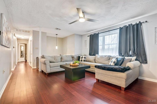 living room featuring a textured ceiling, ceiling fan, and dark hardwood / wood-style floors