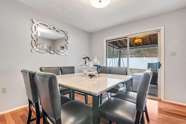 dining room featuring a textured ceiling and light hardwood / wood-style flooring